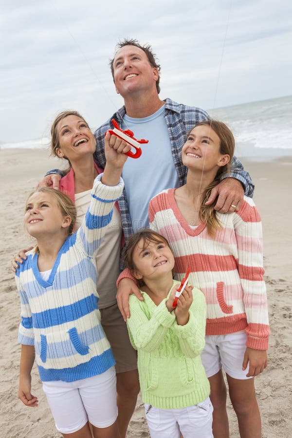 A família Parents as crianças da menina que voam o papagaio na praia fotos de stock A família Parents as crianças da menina que voam o papagaio na praia fotos de stock