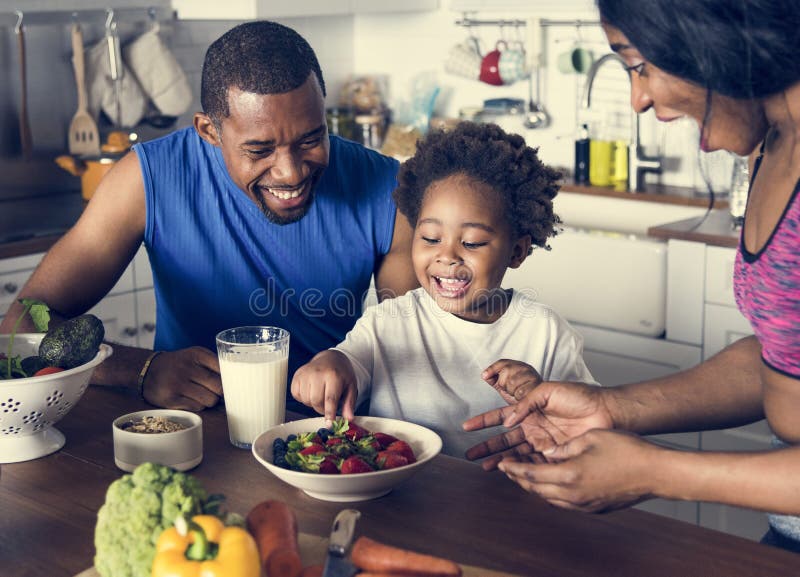 Família preta que come o alimento saudável junto