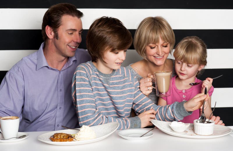 Família que aprecia o café da manhã em um restaurante imagem de stock Família que aprecia o café da manhã em um restaurante imagem de stock