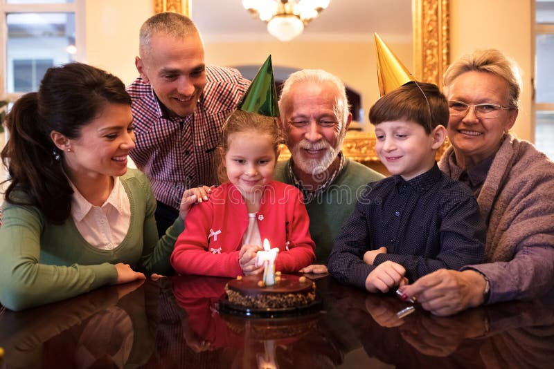 Família que comemora as meninas birrhday em casa foto de stock royalty free Família que comemora as meninas birrhday em casa foto de stock royalty free