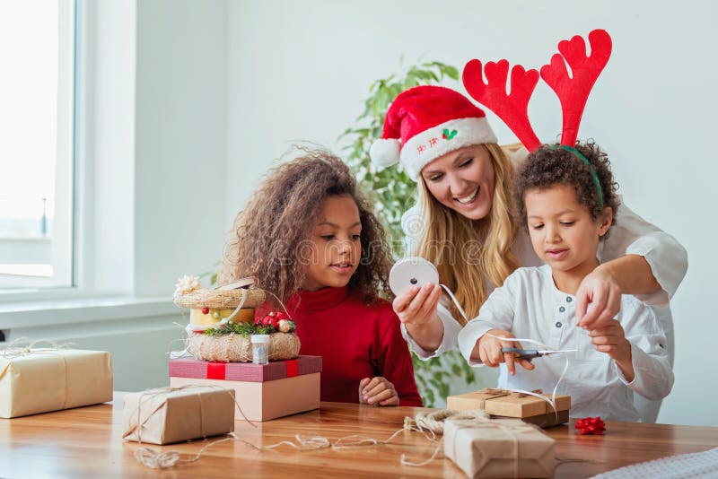 Família que envolve presentes de Natal na tabela fotos de stock Família que envolve presentes de Natal na tabela fotos de stock