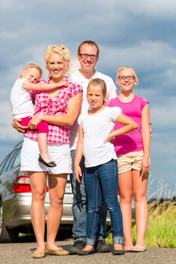 Família que está junto na frente do carro imagens de stock royalty free Família que está junto na frente do carro imagens de stock royalty free