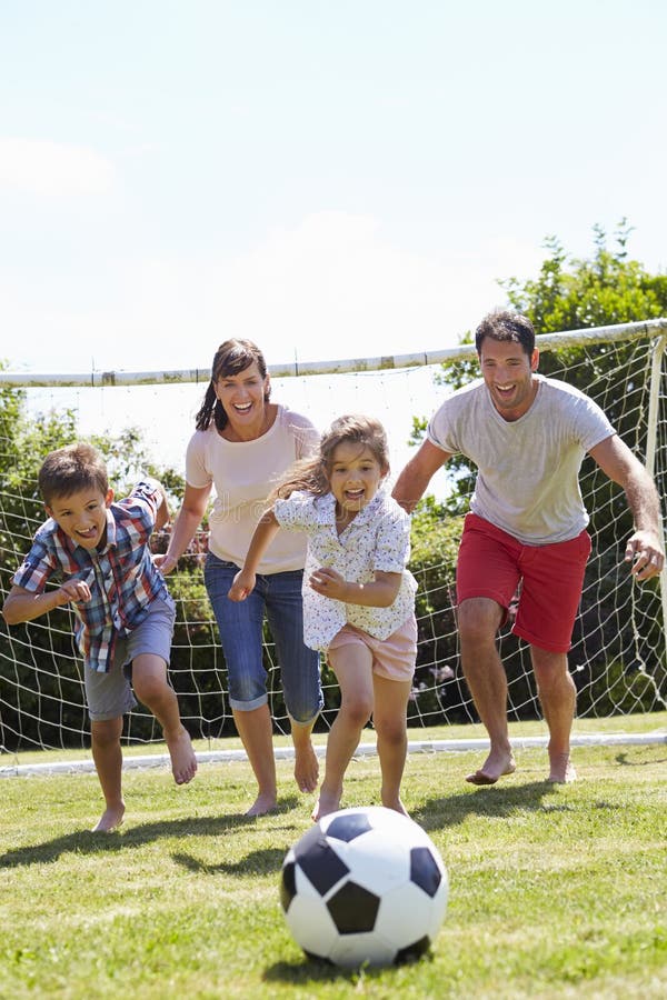 Família que joga o futebol no jardim junto fotos de stock Família que joga o futebol no jardim junto fotos de stock