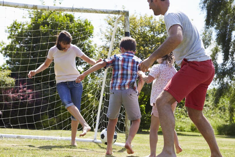 Família que joga o futebol no jardim junto fotos de stock Família que joga o futebol no jardim junto fotos de stock
