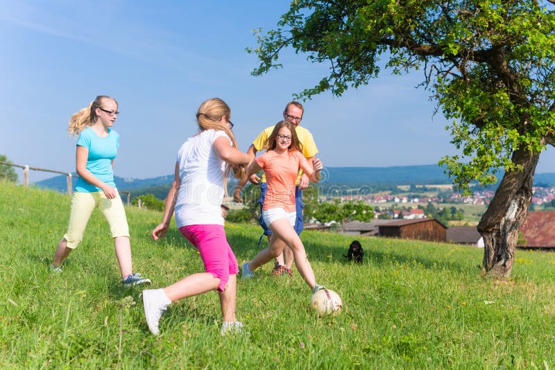 Família que joga o futebol no prado no verão fotos de stock Família que joga o futebol no prado no verão fotos de stock