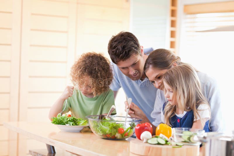 Família a preparar uma salada em conjunto foto de stock