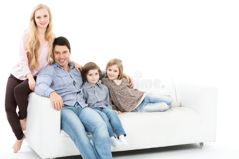 Família que senta-se junto no sofá isolado foto de stock