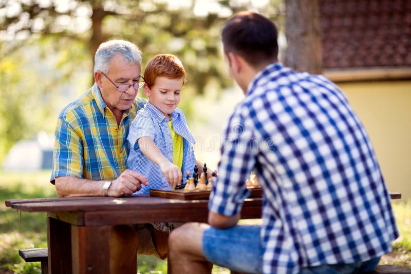 Família que tem o divertimento e que joga a xadrez foto de stock Família que tem o divertimento e que joga a xadrez foto de stock