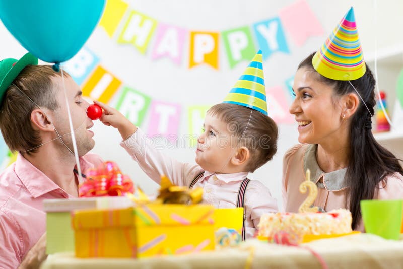 Família que tem o divertimento na festa de anos da criança imagem de stock Família que tem o divertimento na festa de anos da criança imagem de stock