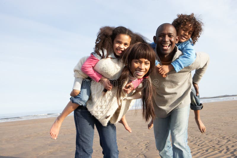 Família que tem o divertimento na praia do inverno imagens de stock Família que tem o divertimento na praia do inverno imagens de stock