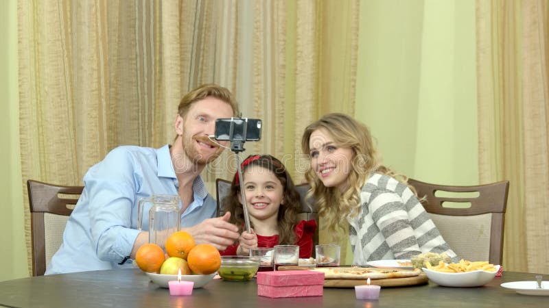 Família que toma o selfie durante o jantar