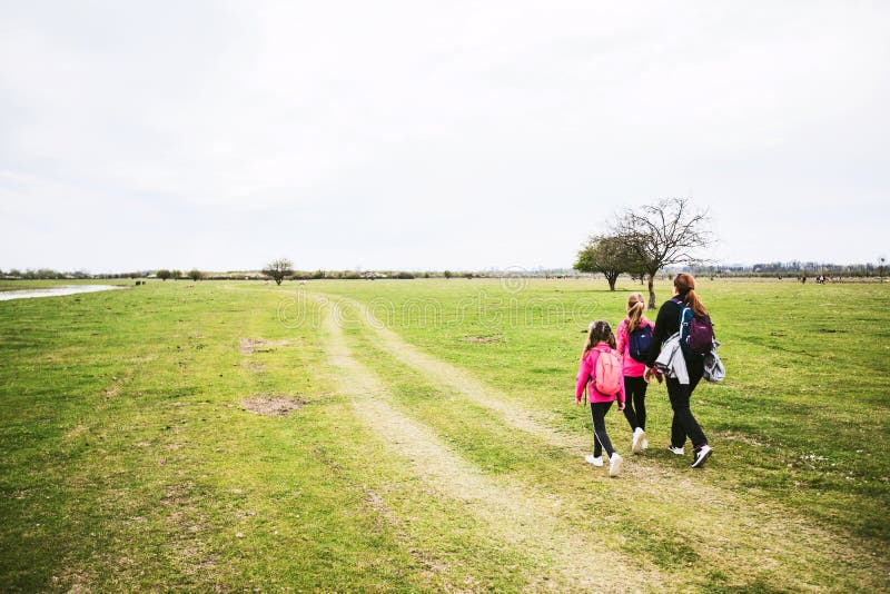 Família relaxa na reserva natural mãe com filhas andando na paisagem natural da primavera fotografia de stock