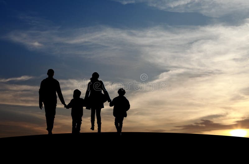 Silhouette of a family comprising a father, mother and two children walking into the sunset. Silhouette of a family comprising a father, mother and two children walking into the sunset.