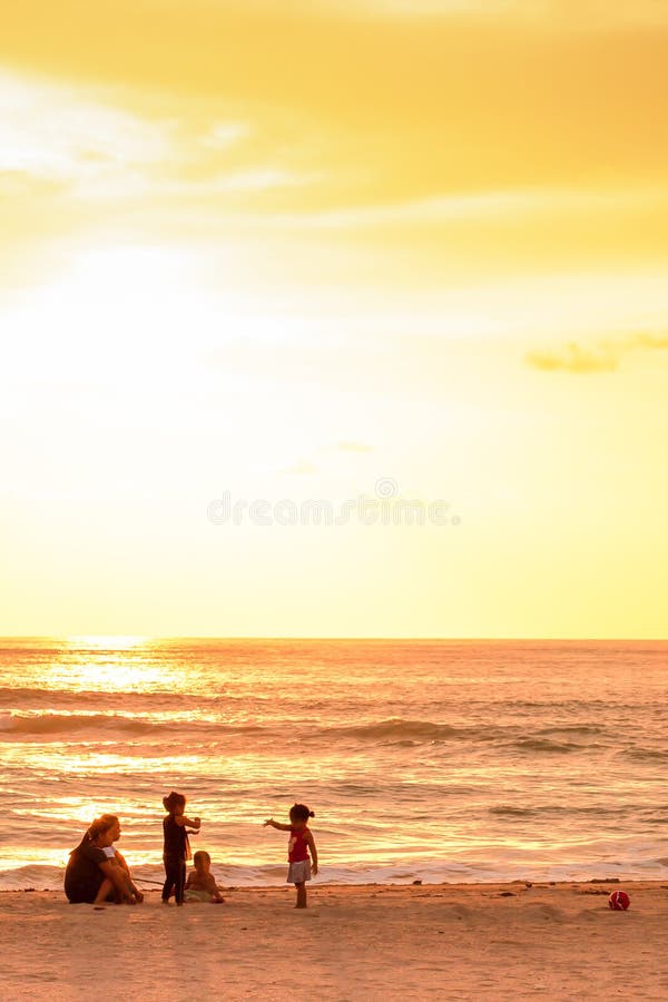 Família tailandesa que relaxa na praia do por do sol, proibição Nam Khem do pescador, Phang Nga, Tailândia foto de stock royalty free Família tailandesa que relaxa na praia do por do sol, proibição Nam Khem do pescador, Phang Nga, Tailândia foto de stock royalty free
