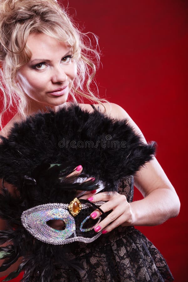 Fan della piuma della maschera di carnevale della tenuta della donna a disposizione immagine stock libera da diritti Fan della piuma della maschera di carnevale della tenuta della donna a disposizione immagine stock libera da diritti