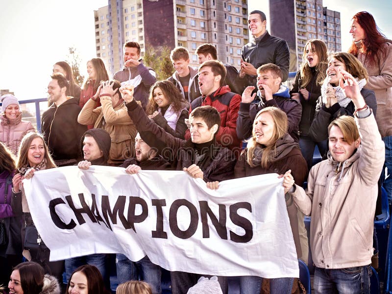 Fans encourageants dans le stade tenant la bannière de champion images stock Fans encourageants dans le stade tenant la bannière de champion images stock