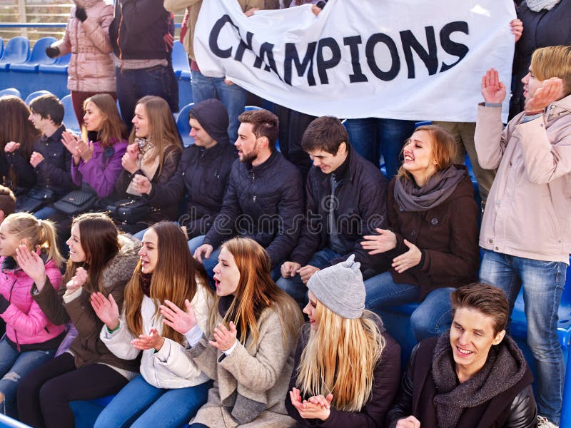 Fans encourageants dans le stade tenant la bannière de champion image libre de droits Fans encourageants dans le stade tenant la bannière de champion image libre de droits