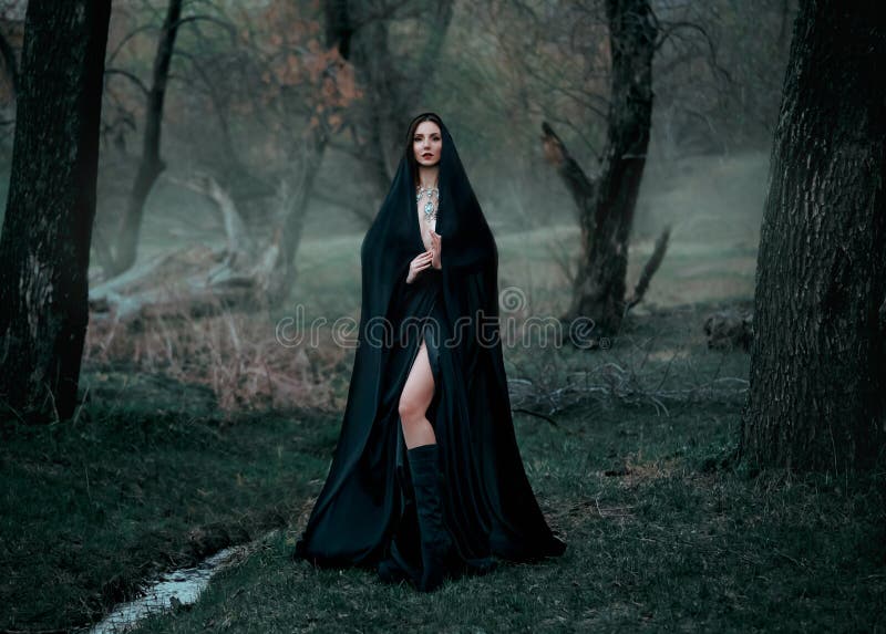 Fantasia misteriosa mulher gótica bruxa escura obcecada pelo mal. vampiro de demônio de menina no capuz de vestido preto. caminhar imagens de stock royalty free