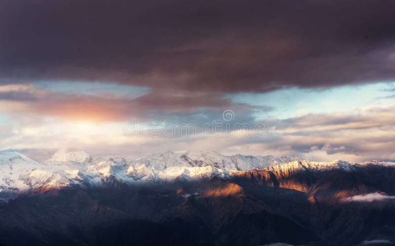 Fantastic snow-capped mountains in the beautiful cumulus clouds.