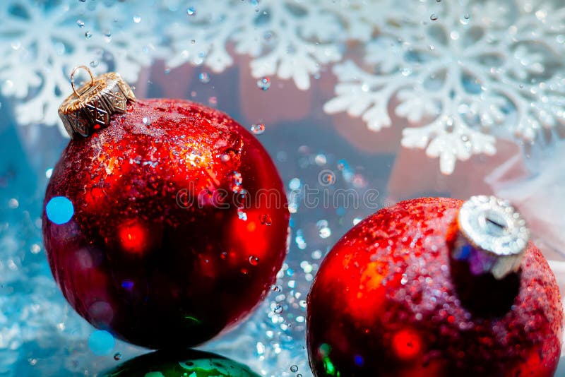 Fancy new year frozen balls with ice water drops bokeh on snowflakes winter background wallpaper. Fancy new year frozen balls with ice water drops bokeh on snowflakes winter background wallpaper