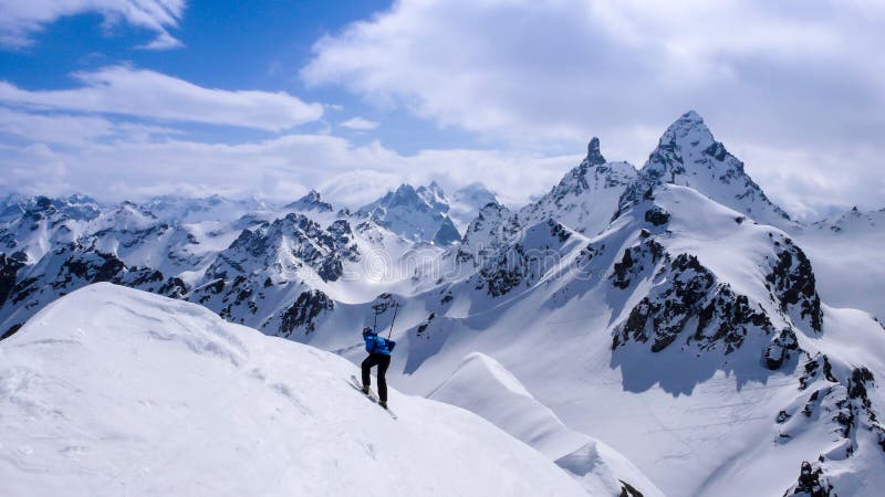 Fantastiskt vinterberglandskap med en manlig glesbygdsområdeskidåkare i förgrunden royaltyfri foto Fantastiskt vinterberglandskap med en manlig glesbygdsområdeskidåkare i förgrunden royaltyfri foto