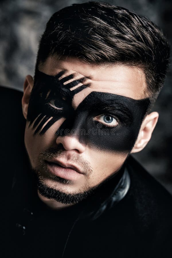 Fantasy art makeup. Young man with black painted mask on face Close up Portrait. Professional Fashion Makeup. stock photos Fantasy art makeup. Young man with black painted mask on face Close up Portrait. Professional Fashion Makeup. stock photos