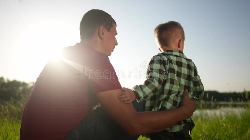 Far och son som går i parken. människor som gillar familj och drömbegrepp om barn. far och barn som håller sonhänder och går