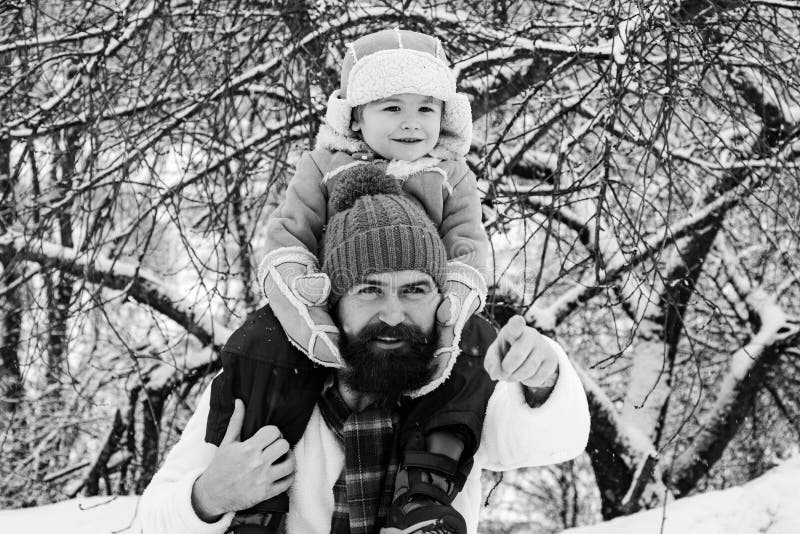 Far som ger son skjuts tillbaka i parken. Söt son kramar sin pappa på vintersemester. Bästa vinterspel för lyckliga familjer royaltyfria bilder