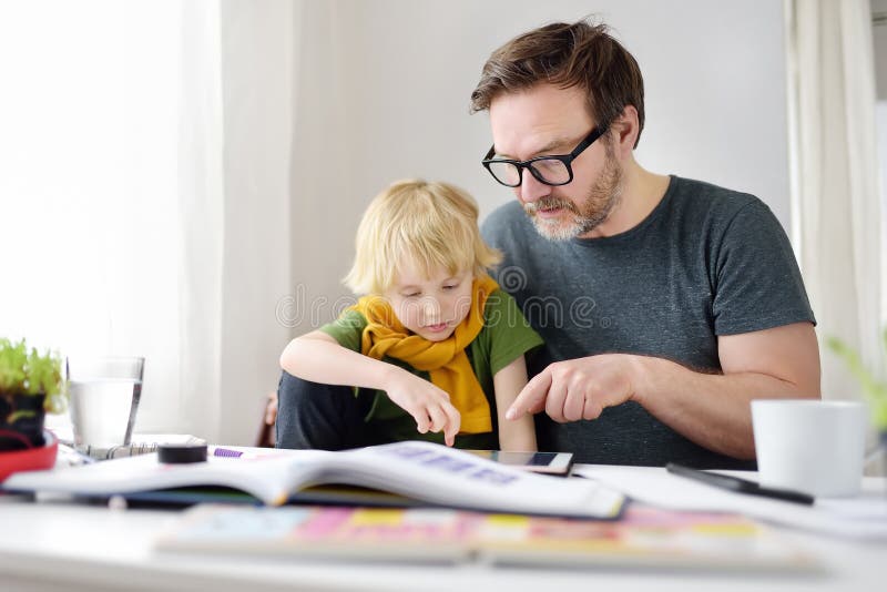 Far som hjälper barn att göra sina läxor hemma. distansundervisning på hemmaplan online för att studera fjärrundervisning för barn arkivfoto