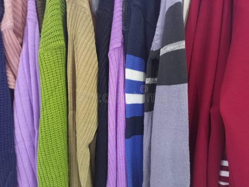 Farbenfrohe Cardigan Collection auf Rack lizenzfreie stockbilder