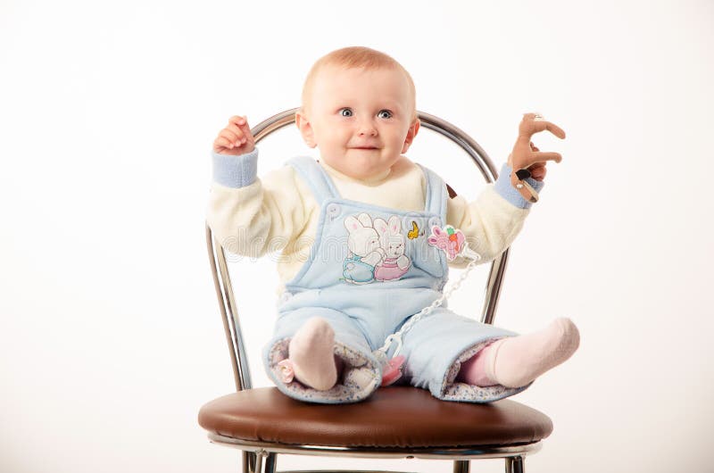 Fare da baby-sitter su una sedia, studio fotografie stock libere da diritti Fare da baby-sitter su una sedia, studio fotografie stock libere da diritti