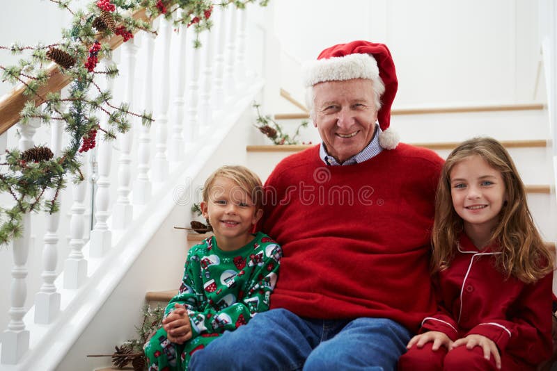 Farfadern med barnbarn sitter på trappa på jul royaltyfria foton Farfadern med barnbarn sitter på trappa på jul royaltyfria foton
