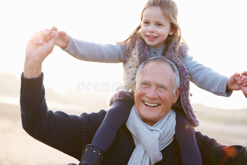 Farfar och sondotter som går på vinterstranden royaltyfri foto Farfar och sondotter som går på vinterstranden royaltyfri foto