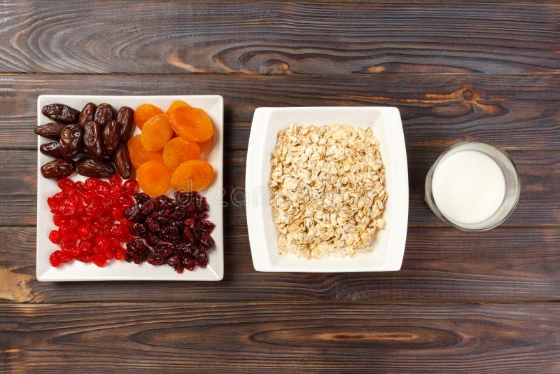 Farine d'avoine avec du lait et des fruits secs Fond en bois foncé de petit déjeuner utile et sain, vue supérieure photographie stock libre de droits Farine d'avoine avec du lait et des fruits secs Fond en bois foncé de petit déjeuner utile et sain, vue supérieure photographie stock libre de droits
