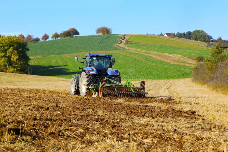 Farma traktoru na polní práce, orba půdy.