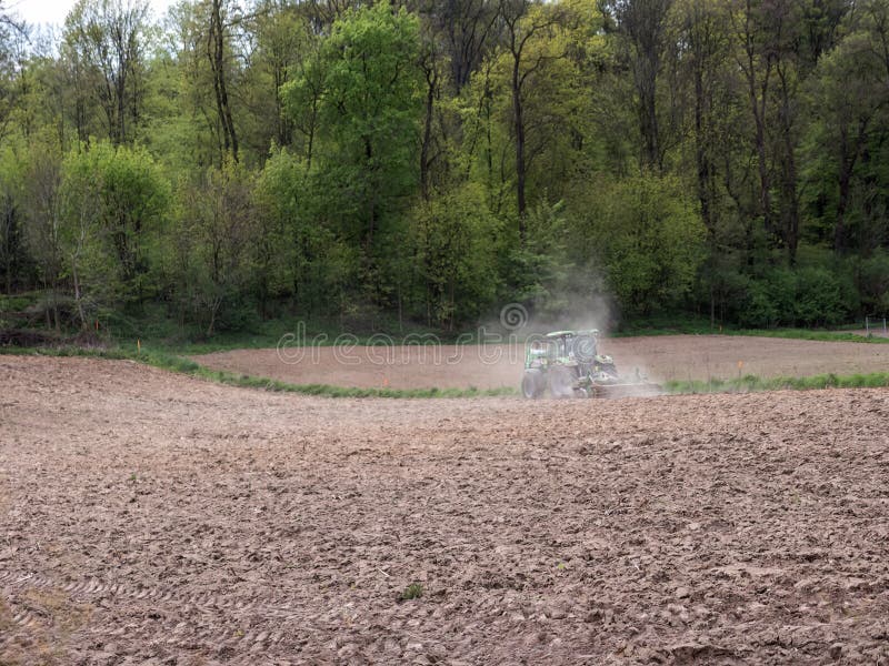 Farm tractor harrowing arable field stock images