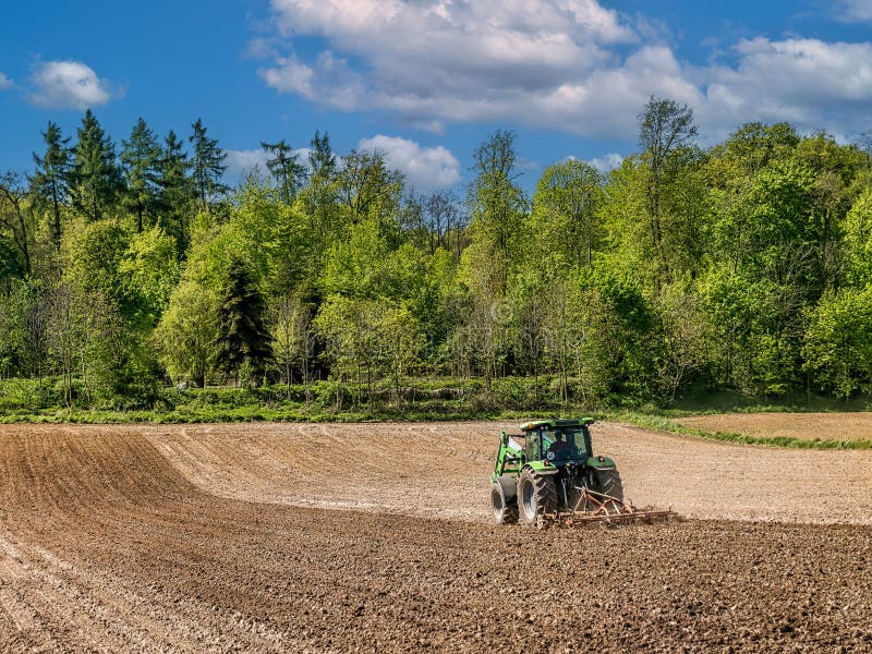 Farm tractor harrowing arable field stock image