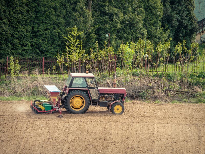 Farm tractor with sowing machine working in the arable field royalty free stock photos