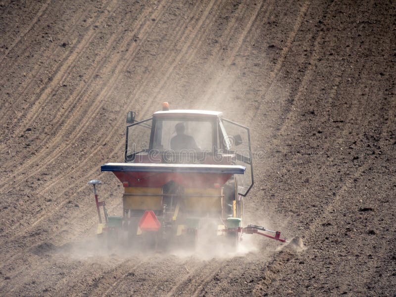 Farm tractor with sowing machine working in the arable field royalty free stock photos