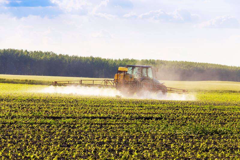 Farm tractor spraying a field.