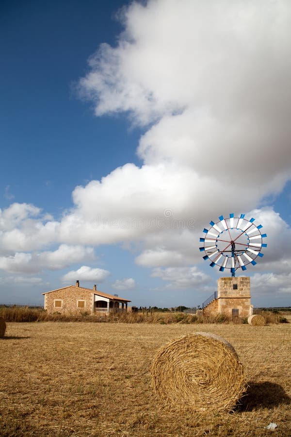 Farm windmill and hay bale