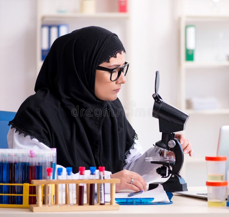 Farmacista femmina in hijab al lavoro in laboratorio fotografia stock libera da diritti