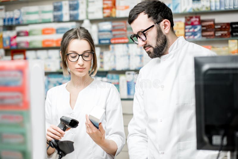 Farmacisti che lavorano nel deposito della farmacia immagini stock libere da diritti Farmacisti che lavorano nel deposito della farmacia immagini stock libere da diritti
