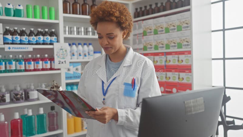 Farmacéutica afroamericana revisa medicamentos en una farmacia moderna fotografía de archivo libre de regalías