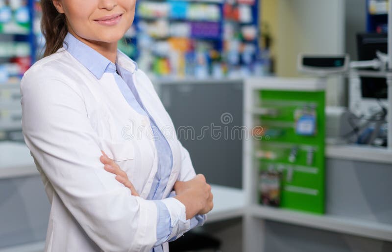 Farmacéutico hermoso de la mujer que se coloca en su lugar de trabajo en farmacia imágenes de archivo libres de regalías Farmacéutico hermoso de la mujer que se coloca en su lugar de trabajo en farmacia imágenes de archivo libres de regalías