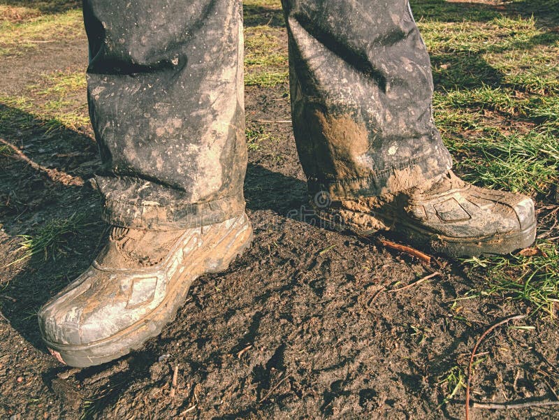 Farmer wearing muddy boots in daily business. Muddy rubber boot in horse farm area. Farmer wearing muddy boots in daily business. Muddy rubber boot in horse farm area