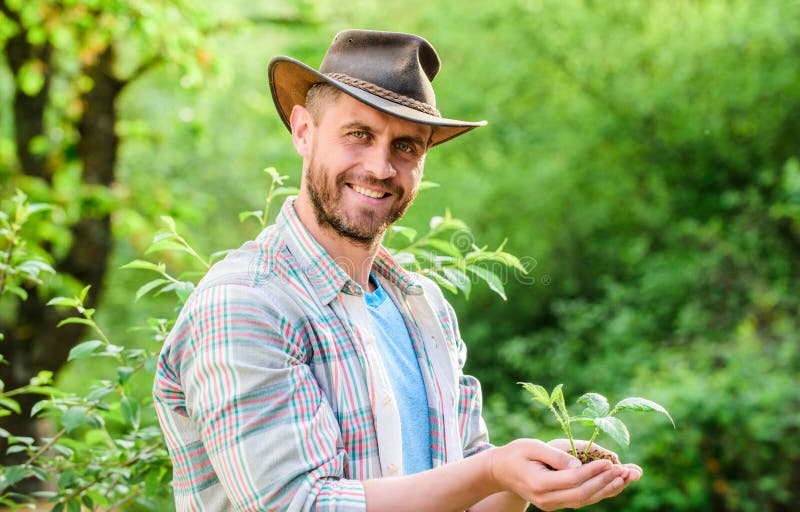 Farming and agriculture cultivation. Gardening. muscular ranch man in cowboy hat care plants. Eco farm worker. Earth day royalty free stock images Farming and agriculture cultivation. Gardening. muscular ranch man in cowboy hat care plants. Eco farm worker. Earth day royalty free stock images