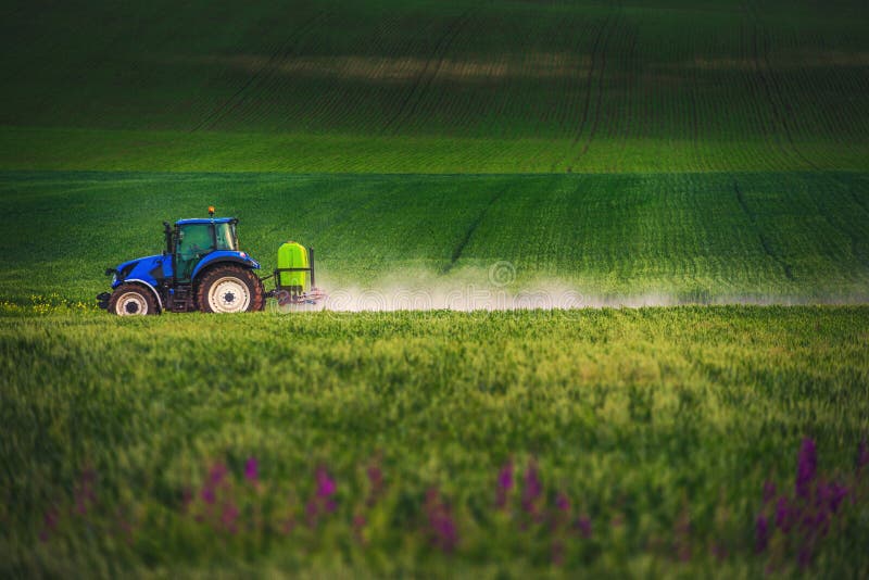 Farming tractor plowing and spraying on field stock images Farming tractor plowing and spraying on field stock images