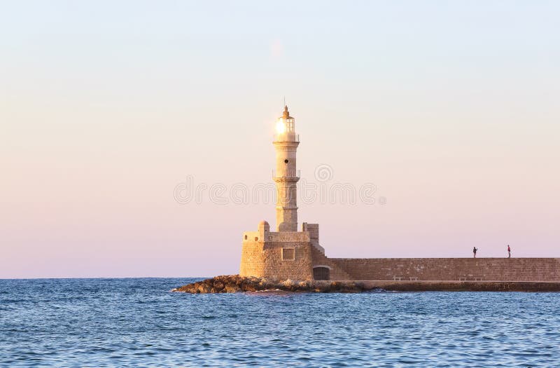 Faro alto, hermoso, antiguo hecho de ladrillos La puesta del sol maravillosa enciende el cielo Centro turístico turístico Chania, fotografía de archivo Faro alto, hermoso, antiguo hecho de ladrillos La puesta del sol maravillosa enciende el cielo Centro turístico turístico Chania, fotografía de archivo