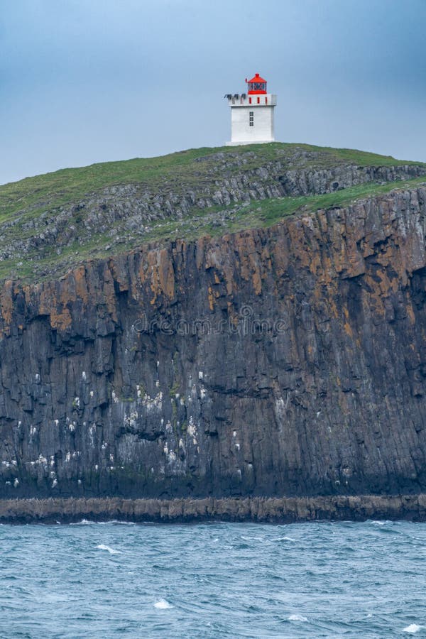 Faro en la isla elliadeg aey ellidaey con acantilados basálticos en la bahía breidafjapara rdur.